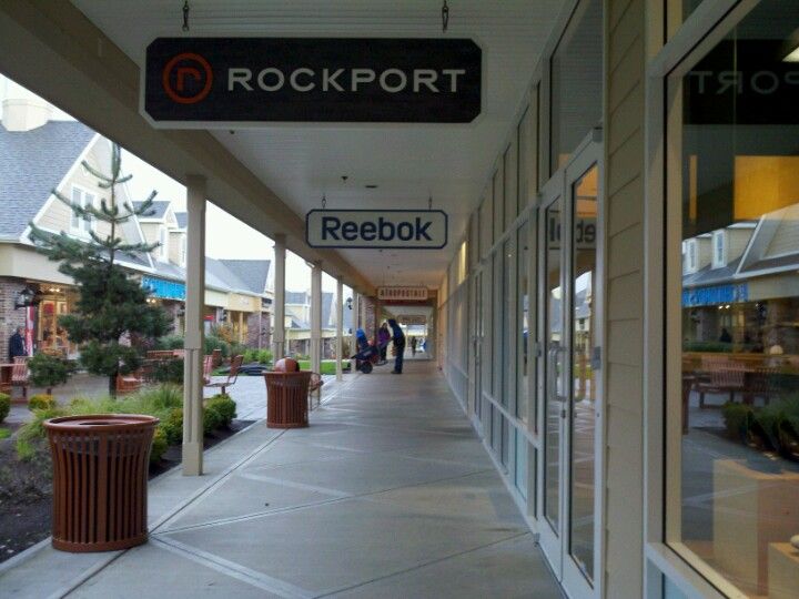 the store front of rockport shopping center with people walking down the walkway and shops on both sides