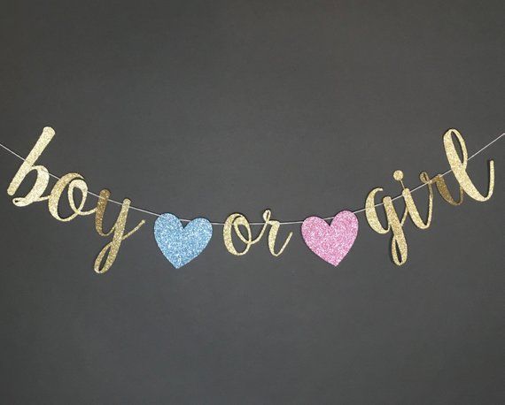 a banner that says boy or girl hanging from a string with glitter hearts on it