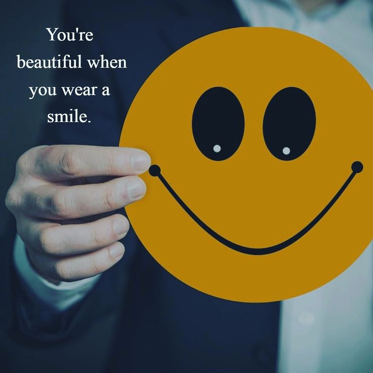 a person holding up a smiley face with the words you're beautiful when you wear a smile