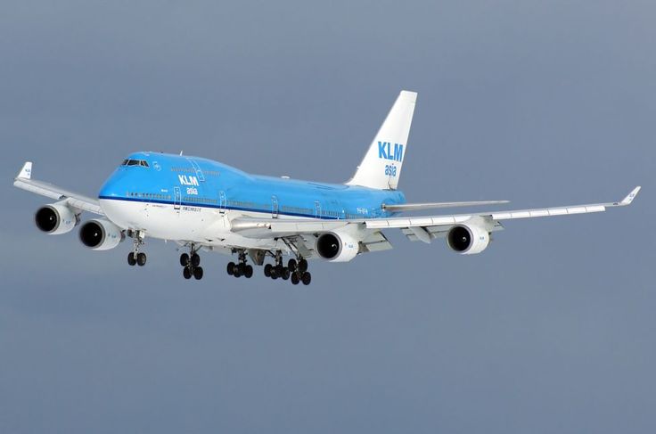 an airplane flying in the sky with it's landing gear down and wheels out