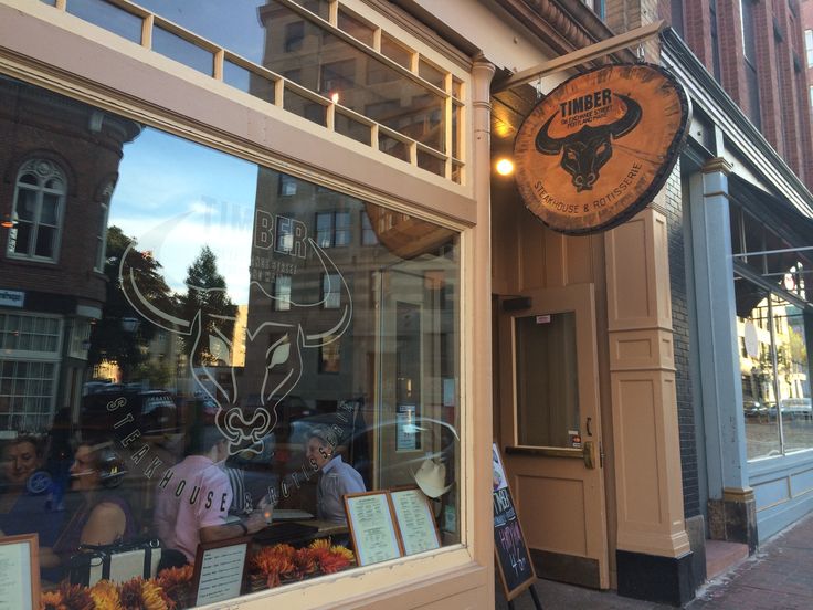 an outside view of a restaurant with people looking in the window