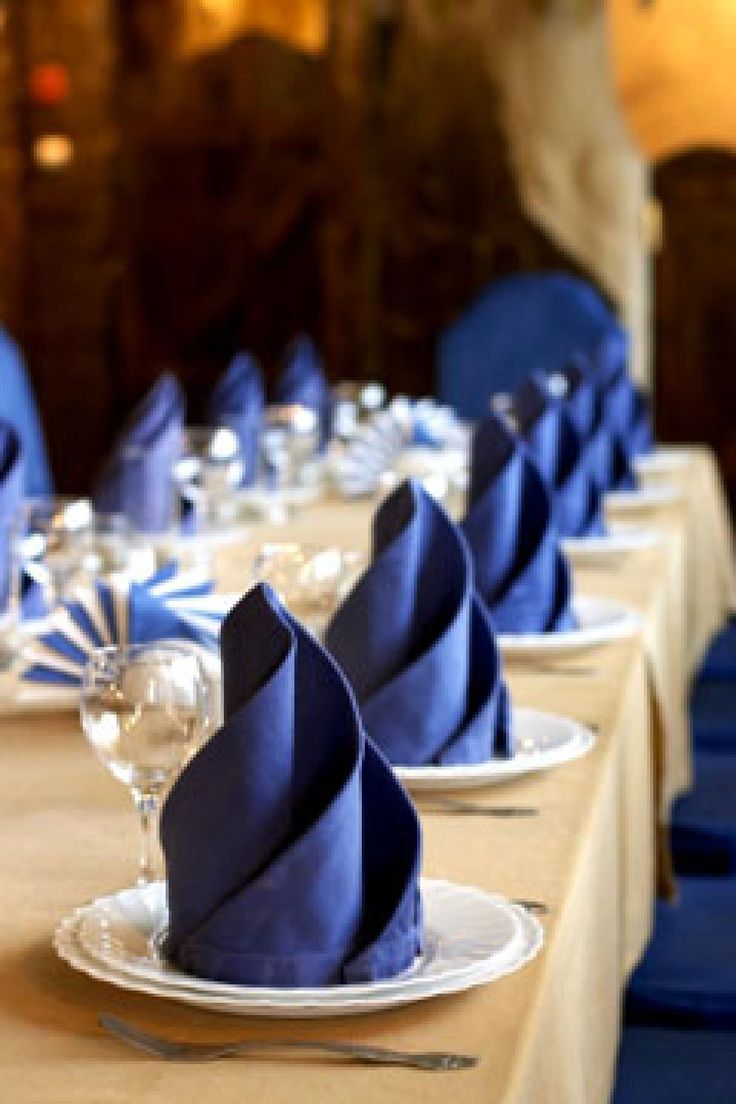 the table is set with blue napkins and wine glasses