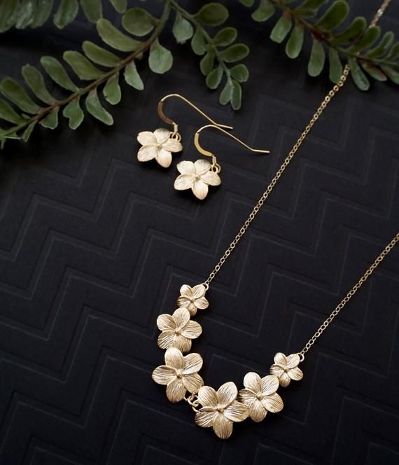 Gold plumeria flower jewelry set - plumeria necklace, plumeria earrings, Hawaii jewelry, plumeria lei necklace, feminine jewelry, delicate jewelry, dainty jewelry, bridesmaids gift idea, wedding jewelryThis beautiful jewelry set features gold plated plumeria flowers suspended on a delicate 14K gold filled chain, and a set of  matching single plumeria flowers earrings.   A lovely jewelry set that reminds me of Hawaii.Dimension:----------------Plumeria lei: 3 inchesTotal necklace length: 17 inches Nickel-free Flower-shaped Jewelry For Jewelry Making, Nature-inspired Flower Jewelry As A Gift For Her, Nature-inspired Jewelry With Flower Charm For Anniversary, Nature-inspired Gold Jewelry With Matching Earrings, Nature-inspired Jewelry With Flower Charm, Botanical Dangle Matching Earrings Jewelry, Botanical Style Jewelry With Matching Dangle Earrings, Elegant Brass Jewelry With Birth Flower Detail, Brass Flower-shaped Jewelry For Gifts