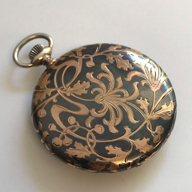 RARE ANTIQUE Silver case with Niello & Rose Gold Patterning Pocket Watch c.1915. Silver cased pocket watch with Niello & rose gold floral patterning to rear of case. Inner cover having the inscription '11 November 1890 - 11 November 1915'. Rare dial having black arabic numerals and minute index set in guilded chapter ring. Guilded subsidiary seconds dial at 6 o'clock and copper and silver vertical stripes to centre of dial. Dial signed 'Tavannes Watch Co'. Blue steel hands. Mechanical Swiss Lever movement. Bow wound & hand set. Case hallmarked 0.900 continental silver. Please note this a most rare watch. Watch dimensions - 47mm diameter. Height inc. bow 61mm. This watch is sold with a 12 month guarantee from Fine Times MBHI certificated watchmakers, established 1947. All watches will be se Victorian Engraved Watches For Formal Occasions, Victorian Engraved Watches With Round Dial, Victorian Style Engraved Watch With Round Dial, Victorian Engraved Watch With Round Dial, Formal Victorian Style Pocket Watch, Victorian Pocket Watch For Formal Occasions, Victorian Pocket Watch With Round Dial For Formal Occasions, Timeless Engraved Compact Pocket Watch, Victorian Style Self-winding Pocket Watch For Formal Occasions