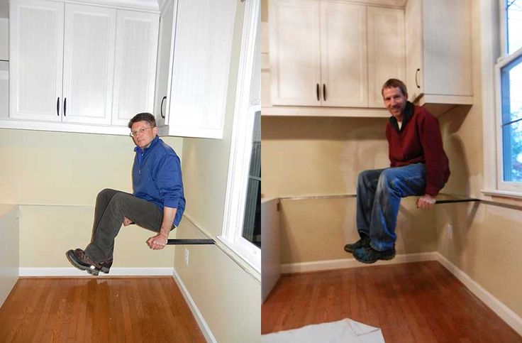 two men are sitting on the kitchen cabinets and one man is jumping in the air