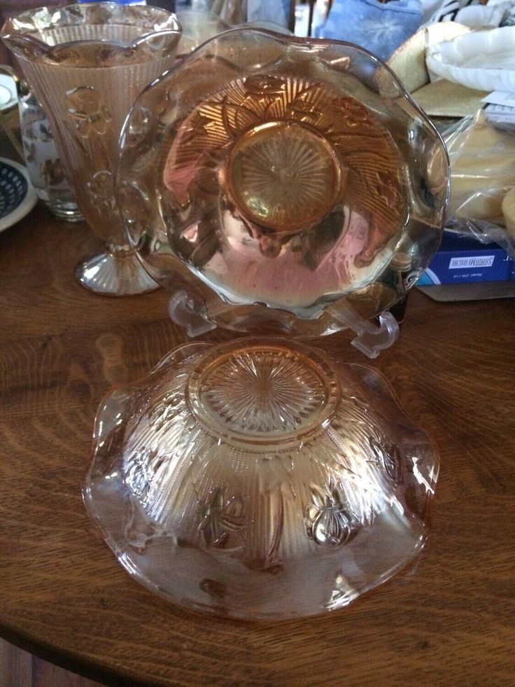 two glass dishes sitting on top of a wooden table