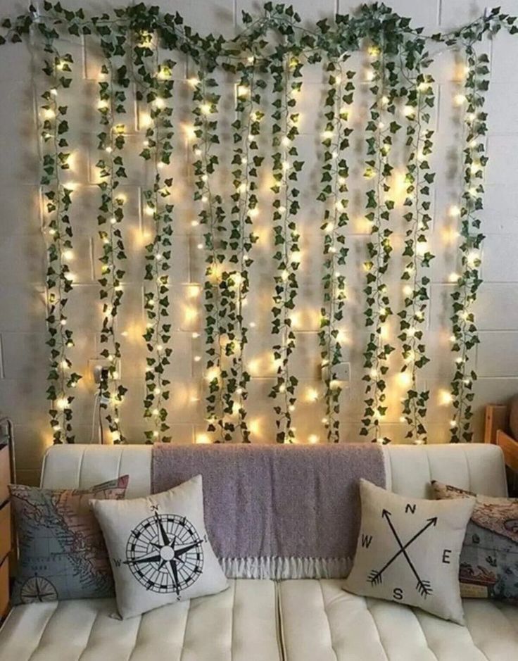 a living room with white couches and lights on the wall above them, along with pillows