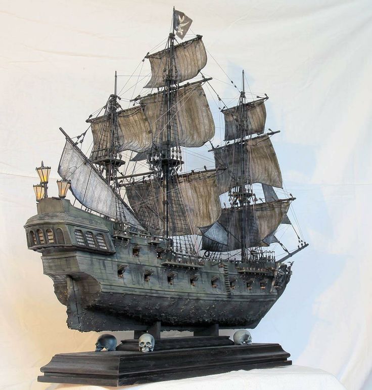 a statue of a pirate ship with sails and two masts on a black base