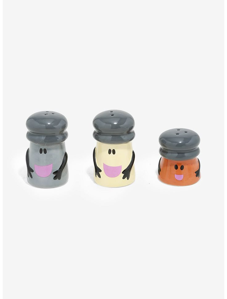 three salt and pepper shakers in the shape of cartoon characters with faces on them