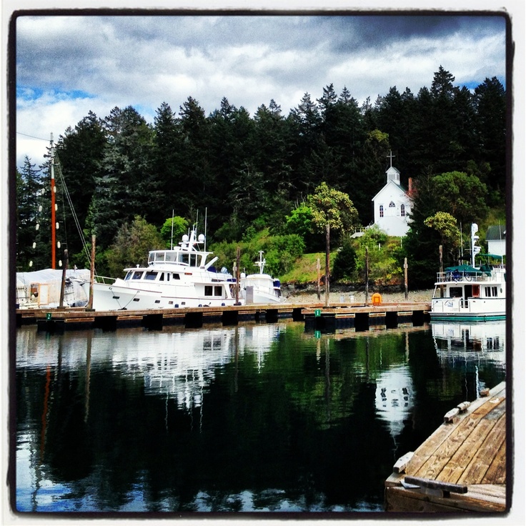 two boats are docked in the water next to a dock with a house on it