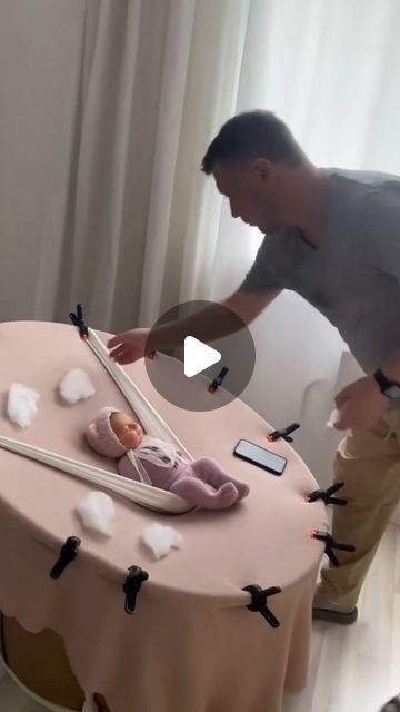 a man standing next to a table with a baby on it