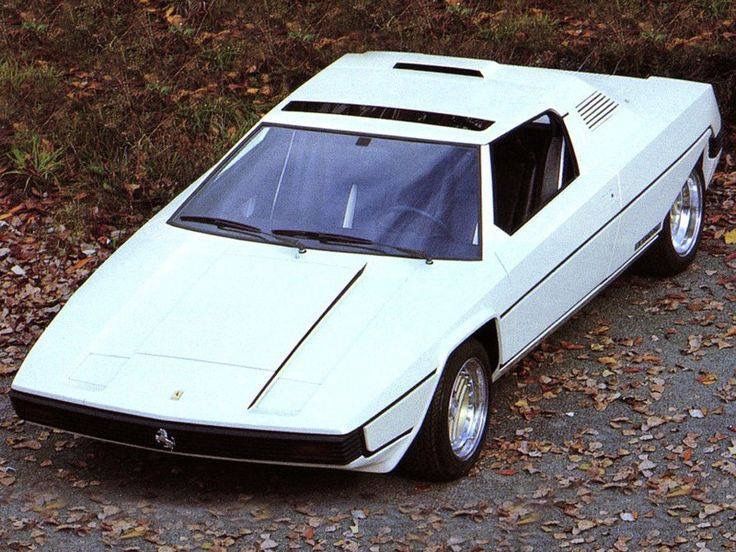 a white sports car parked on the side of a road in front of some trees