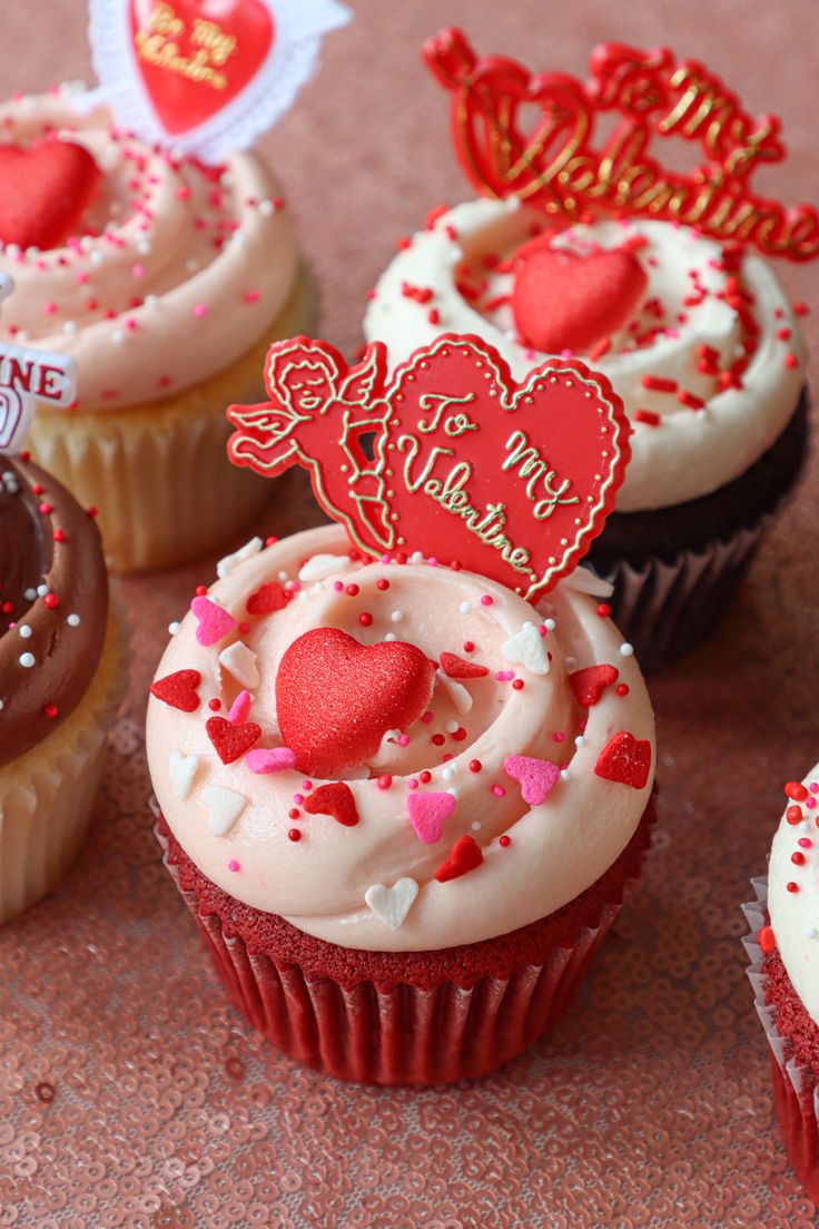 several cupcakes with hearts and decorations on them