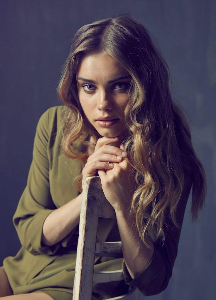 a woman with long hair sitting on a chair