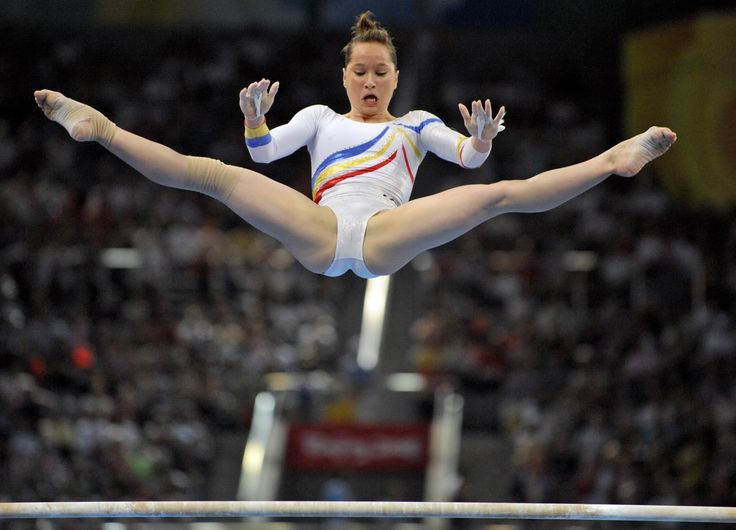 a woman is performing on the balance beam