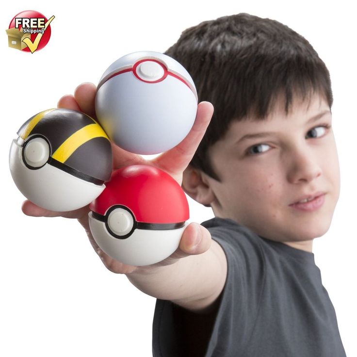 a boy holding three pokemon balls in his hand