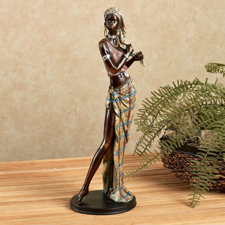 a figurine is standing next to a potted plant on a wooden table