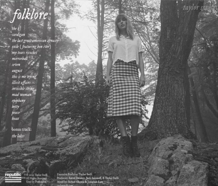 a woman standing in the woods next to a tree with an advertisement for folkloree