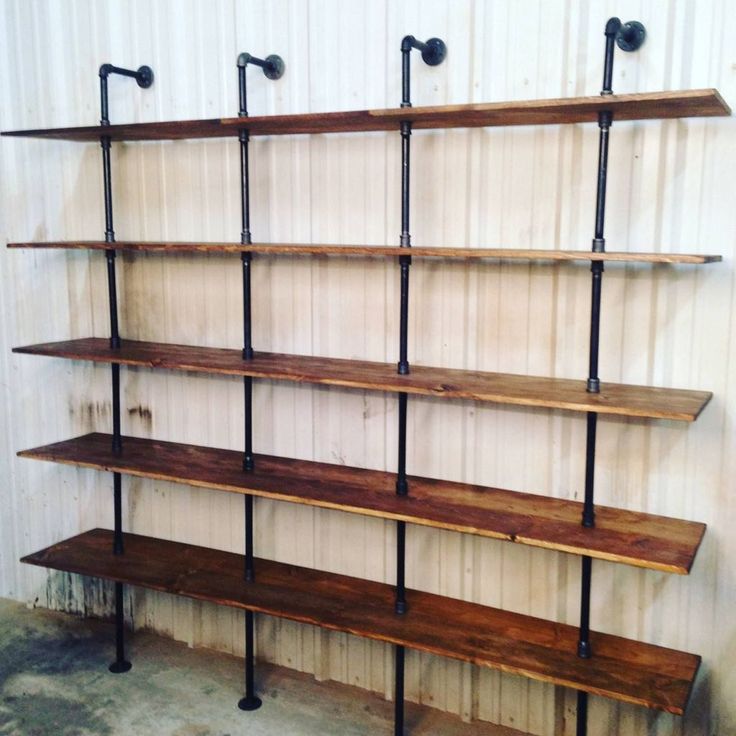 the shelves are made out of wood and have metal pipes on each shelf, along with hooks