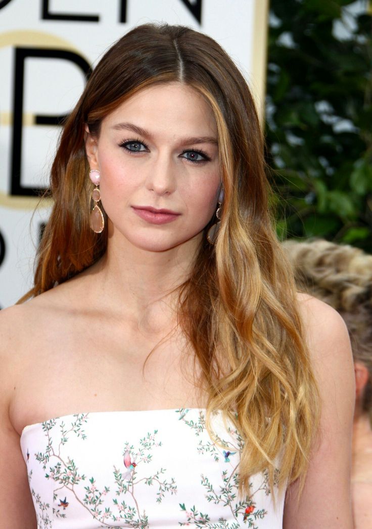 a woman in a strapless dress with long hair and blue eyeshadow at the golden globe awards