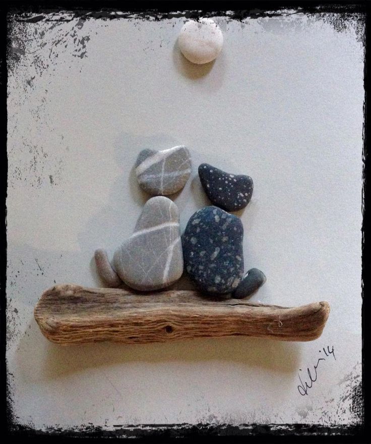 three rocks sitting on top of a piece of driftwood