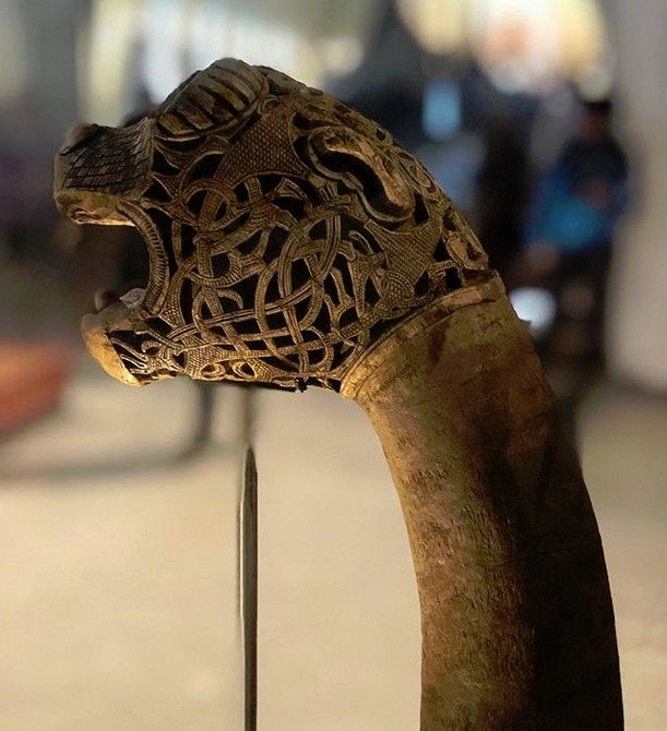 an animal's head is made out of wood and has intricate carvings on it