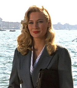 a woman in a business suit standing by the water