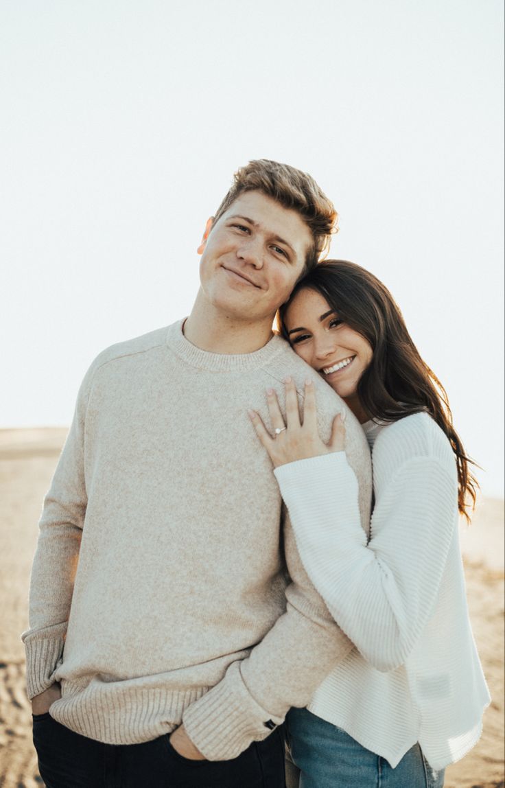 a man and woman hugging on the beach