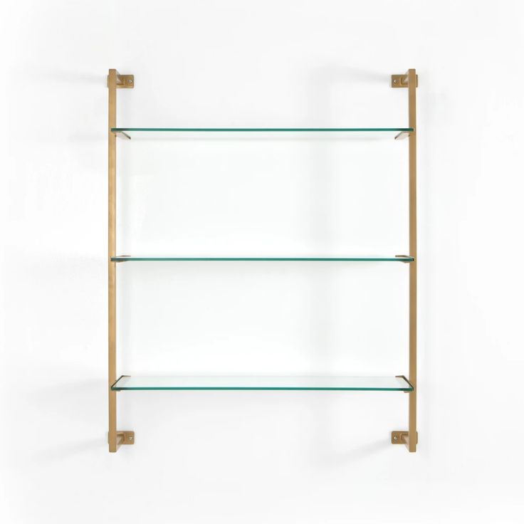 three glass shelves with brass brackets on each shelf, one is empty and the other two are closed