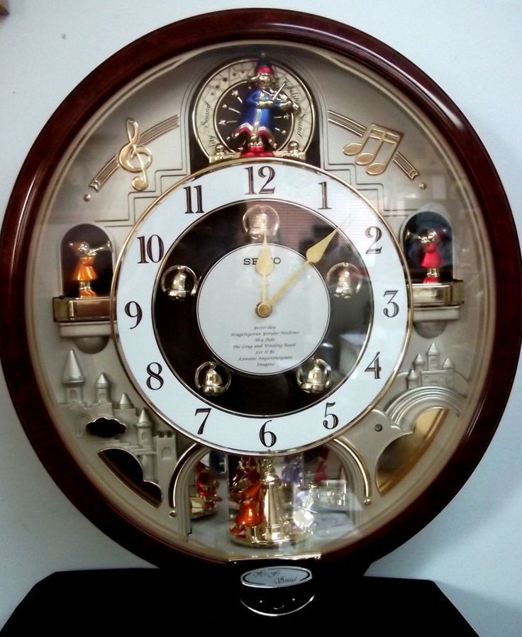 a clock that is sitting on top of a shelf with figurines around it