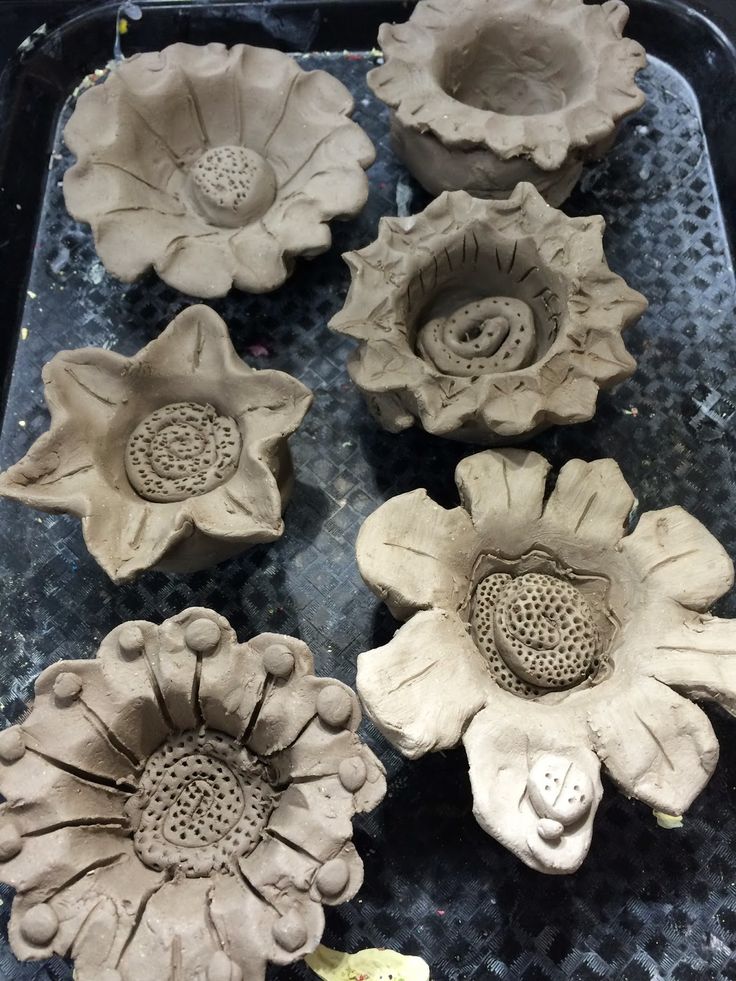 several clay flowers sitting on top of a table