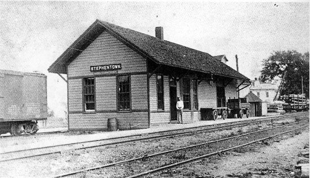 an old photo of a train station and tracks