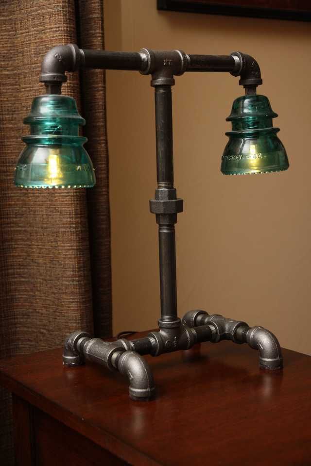 two green glass lamps sitting on top of a wooden table