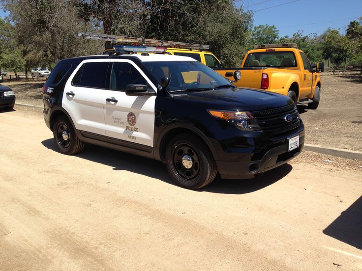 the police car is parked on the side of the road in front of other cars