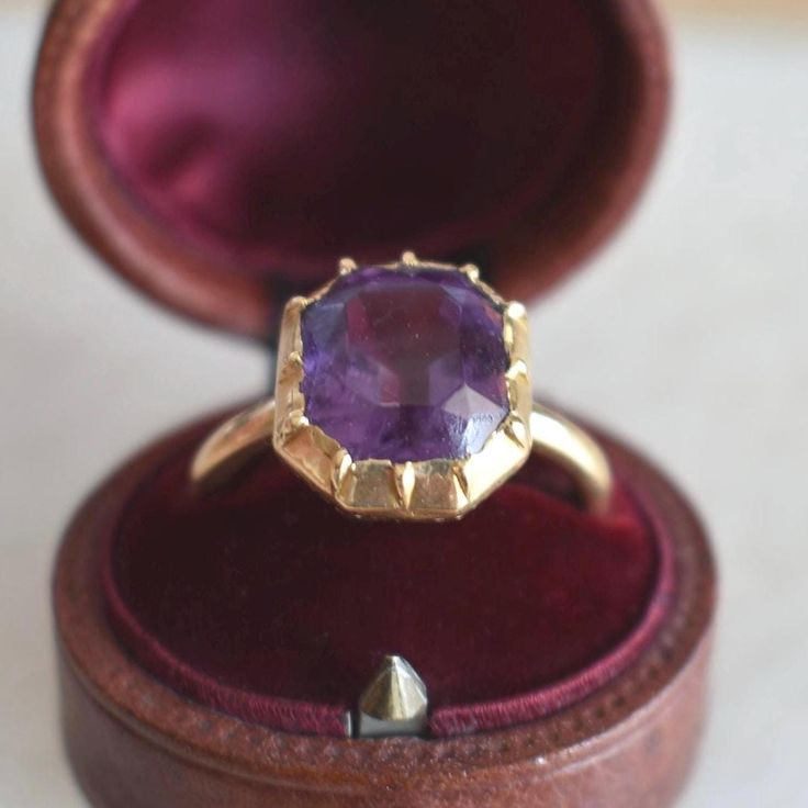 Antique ring from 1850 in 18-carat yellow gold. It features a step-cut amethyst with a deep violet hue, weighing approximately 7 carats (11 x 10 x 7 mm). This ring showcases a tubular-shaped band. Weight: 5.6 g Size: 53 FR (6.5 US - N UK) - Resizing included Metal: 18-carat Gold Stone: Amethyst Amethyst Weight: approx. 7 carats Guarantee Mark: Eagle's head (18-carat gold) Plateau: 13 x 12 mm Free Resizing & Free shipping Delivered with box & certificate You might also like: https://www.etsy.com/ Luxury Purple Ring With Bezel Setting, Luxury Faceted Amethyst Ring For Formal Events, Luxury Faceted Amethyst Ring For Formal Occasions, Faceted Amethyst Ring In Yellow Gold Fine Jewelry, Elegant Faceted Amethyst Ring In Yellow Gold, Luxury Purple Amethyst 14k Gold Ring, Formal Gold Faceted Amethyst Ring, Elegant Gold Faceted Amethyst Ring, Elegant Gold Amethyst Ring With Faceted Detail