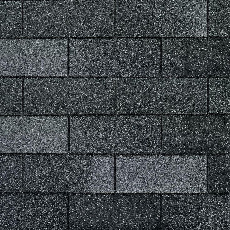 a close up view of a black roof shingled with dark gray and white speckles