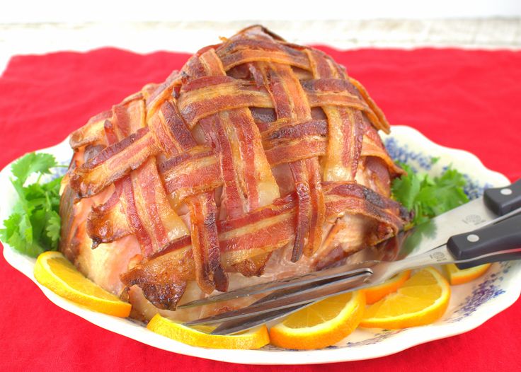 a large piece of meat sitting on top of a white plate next to orange slices