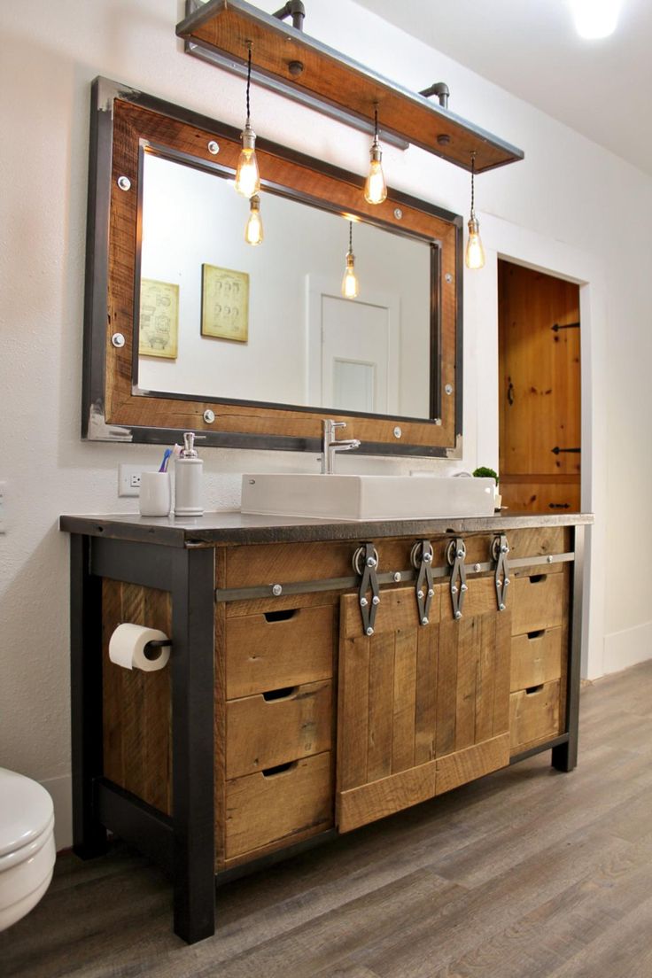 a bathroom with two sinks and a large mirror above the sink is made out of wood