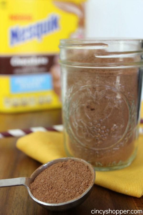 there is a spoon next to a jar of cocoa powder on the table with other ingredients