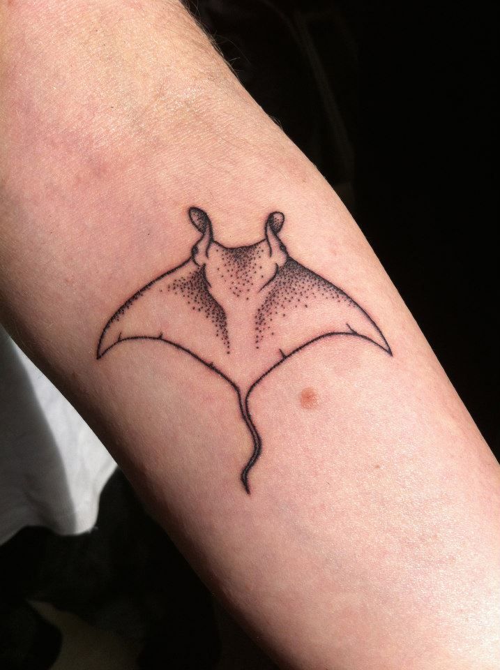 a manta ray tattoo on the arm