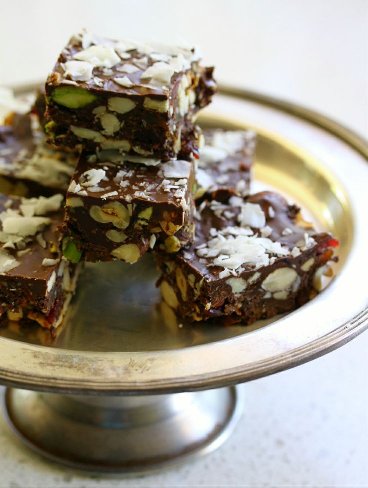 several pieces of chocolate and nuts on a silver platter with a metal serving tray