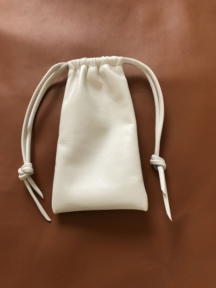 "This leather eyeglass pouch bag is made with a beautiful cream colored Italian Nappa leather. It is so soft and supple. Drawstring closure All of the leather I work with is hand selected by me ensuring you are getting the very best. handcrafted by me Shirlbcreationstoo here in the USA Color -Creme Pouch Size approx overall 6\"H x 3 1/2\"W" Cream Rectangular Pouch For Everyday Use, Cream Rectangular Pouch For Everyday, Everyday Cream Rectangular Pouch, White Leather Pouch With Removable Pouch, Elegant Leather Pouch For Personal Use, Classic Cream Bag For Gift, Classic Cream Bags For Gifts, Classic Cream Bag Perfect For Gifts, White Pouch For Everyday Use