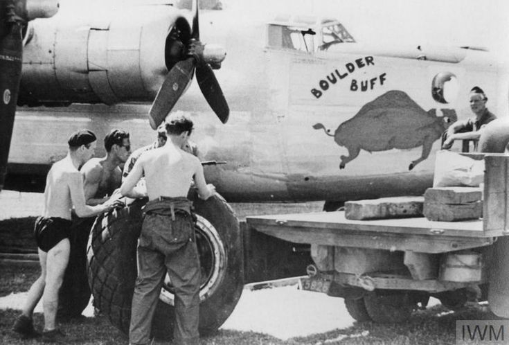 an old black and white photo of men working on a plane