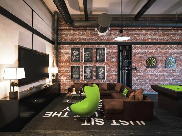 a living room filled with furniture and a pool table in front of a brick wall