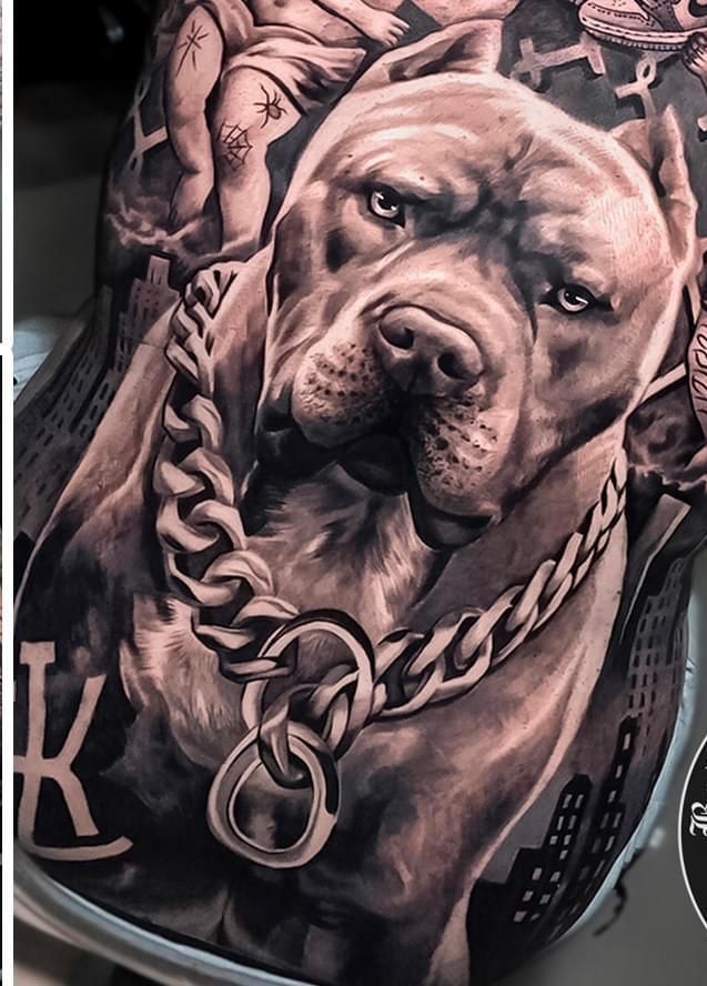 a man with a dog tattoo on his chest and shoulder is holding a chain around his neck