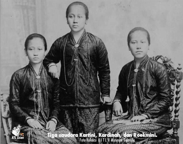 an old black and white photo of three people in native dress, one holding a cane