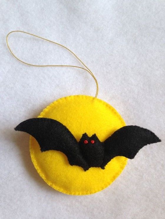 an ornament with a bat hanging from it's side on a white surface