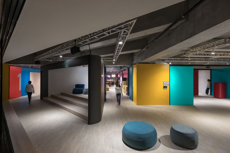 the interior of an art gallery with multiple colored walls and benches in front of them