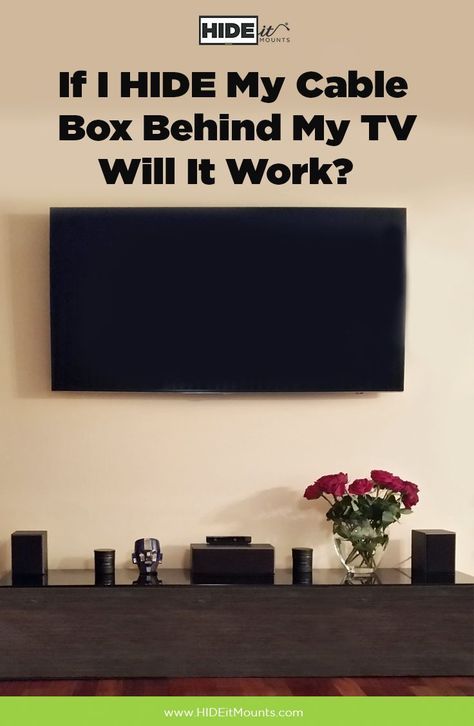 a tv sitting on top of a wooden table next to a vase with flowers in it