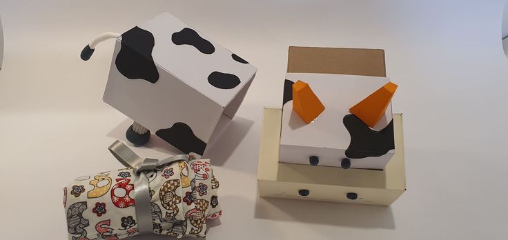 two boxes are made to look like cows and one has a cow's head on it